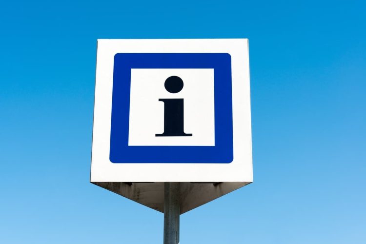 information sign in front of a clear blue sky.